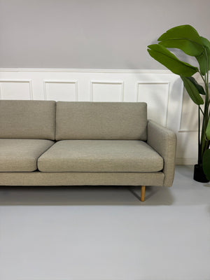 Gebrauchtes graues Bolia Remix Designer Stoff Sofa vor einer Wand, stilvoll und modern eingerichtet.