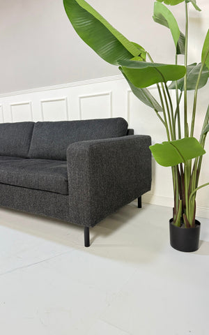 Gebrauchtes Bolia Scandinavia Designer Stoff Sofa in der Farbe Schwarz vor einer Wand, stilvoll und modern eingerichtet.