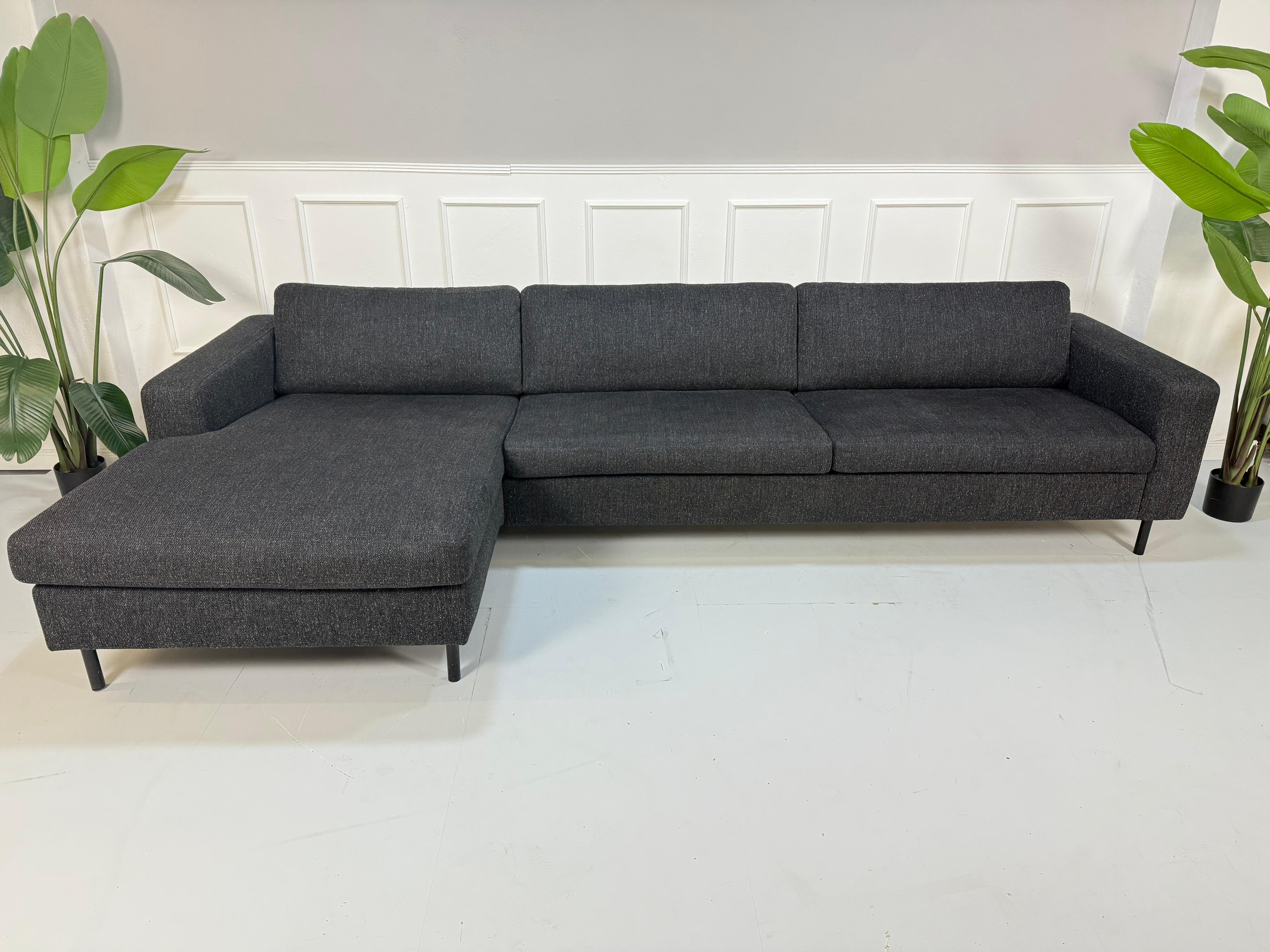 Gebrauchtes Bolia Scandinavia Designer Stoff Sofa in der Farbe Schwarz vor einer Wand, stilvoll und modern eingerichtet.