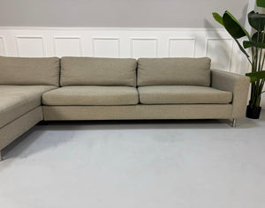 Gebrauchtes graues Bolia Scandinavia 4 Sitzer Designer Stoff Sofa vor einer Wand, stilvoll und modern eingerichtet.