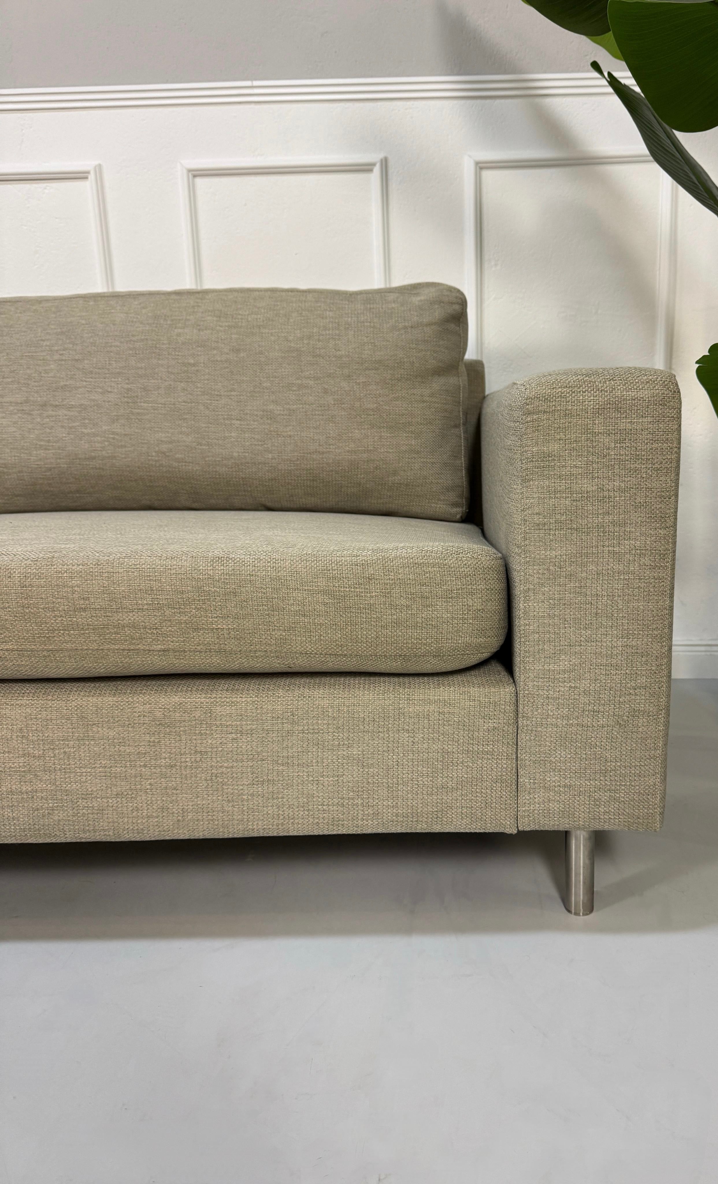 Gebrauchtes graues Bolia Scandinavia 4 Sitzer Designer Stoff Sofa vor einer Wand, stilvoll und modern eingerichtet.