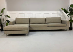 Gebrauchtes graues Bolia Scandinavia 4 Sitzer Designer Stoff Sofa vor einer Wand, stilvoll und modern eingerichtet.