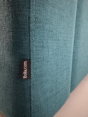 Gebrauchtes türkis Bolia Scandinavia Designer Stoff Sofa vor einer Wand, stilvoll und modern eingerichtet.