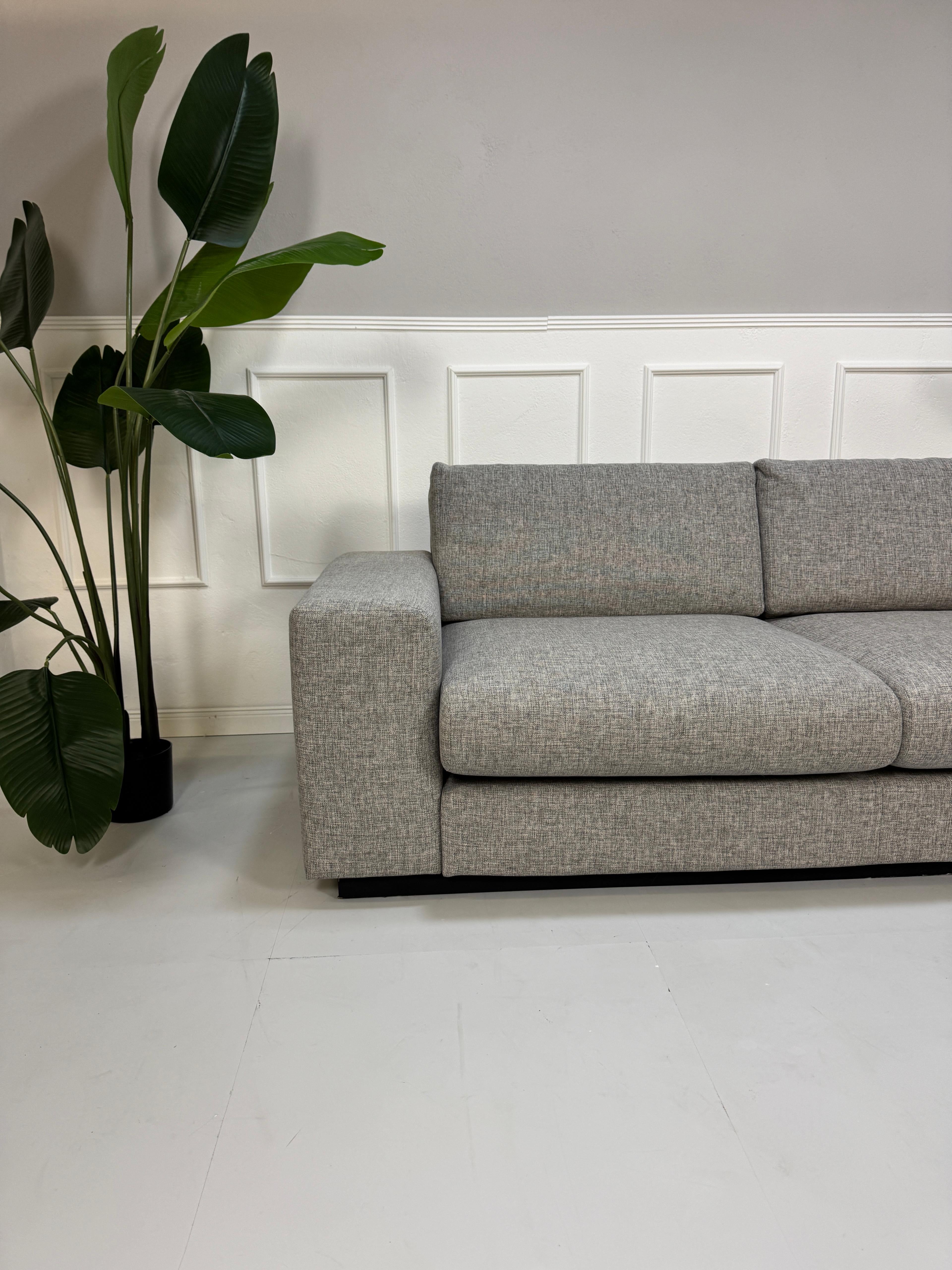 Gebrauchtes Bolia Sepia Stoff Sofa in der Farbe Grau vor einer Wand, stilvoll und modern eingerichtet.