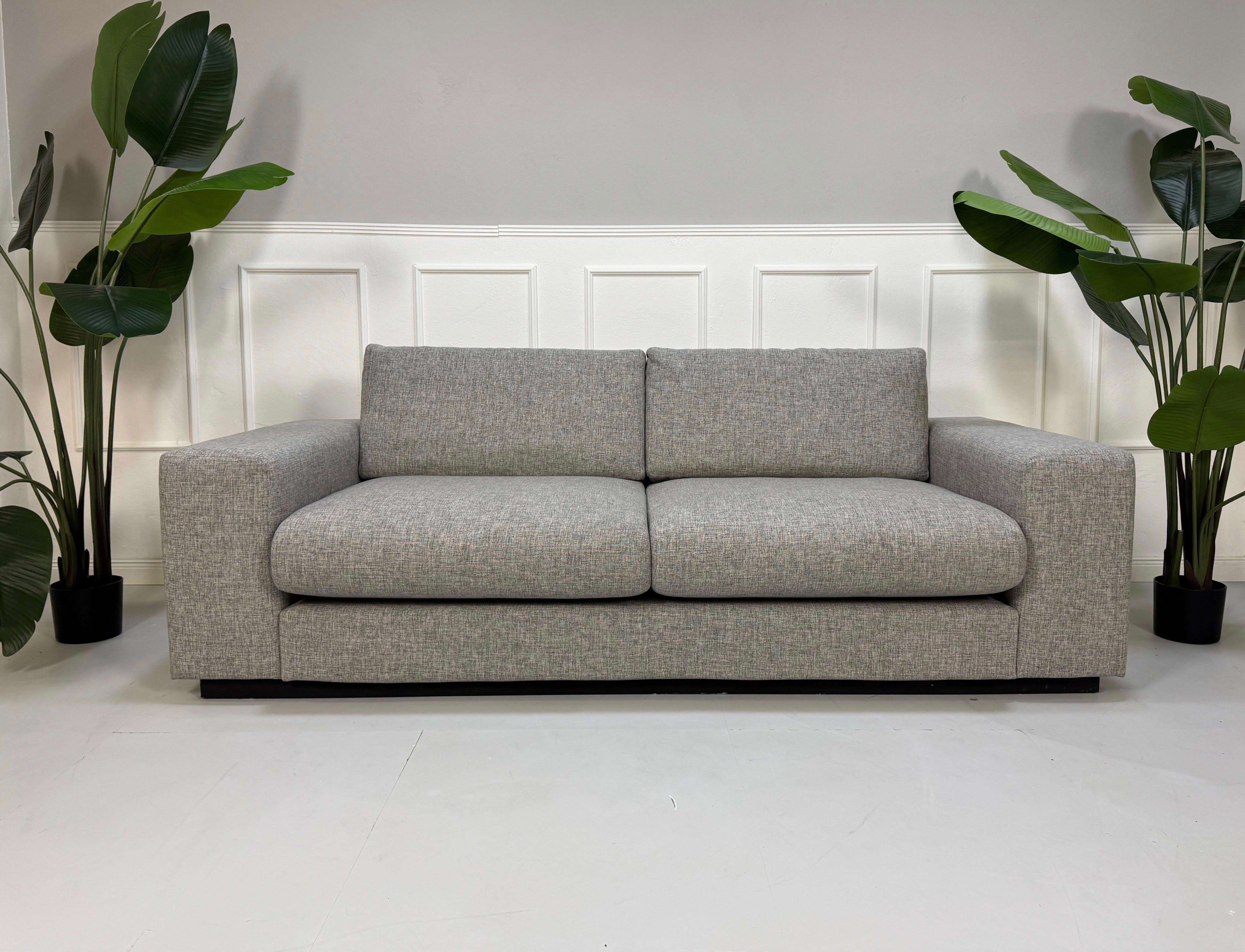 Gebrauchtes Bolia Sepia Stoff Sofa in der Farbe Grau vor einer Wand, stilvoll und modern eingerichtet.