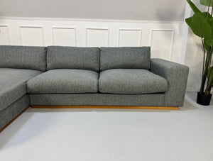 Refurbished graues Bolia Sepia Designer Stoff Sofa vor einer Wand, stilvoll und modern eingerichtet.