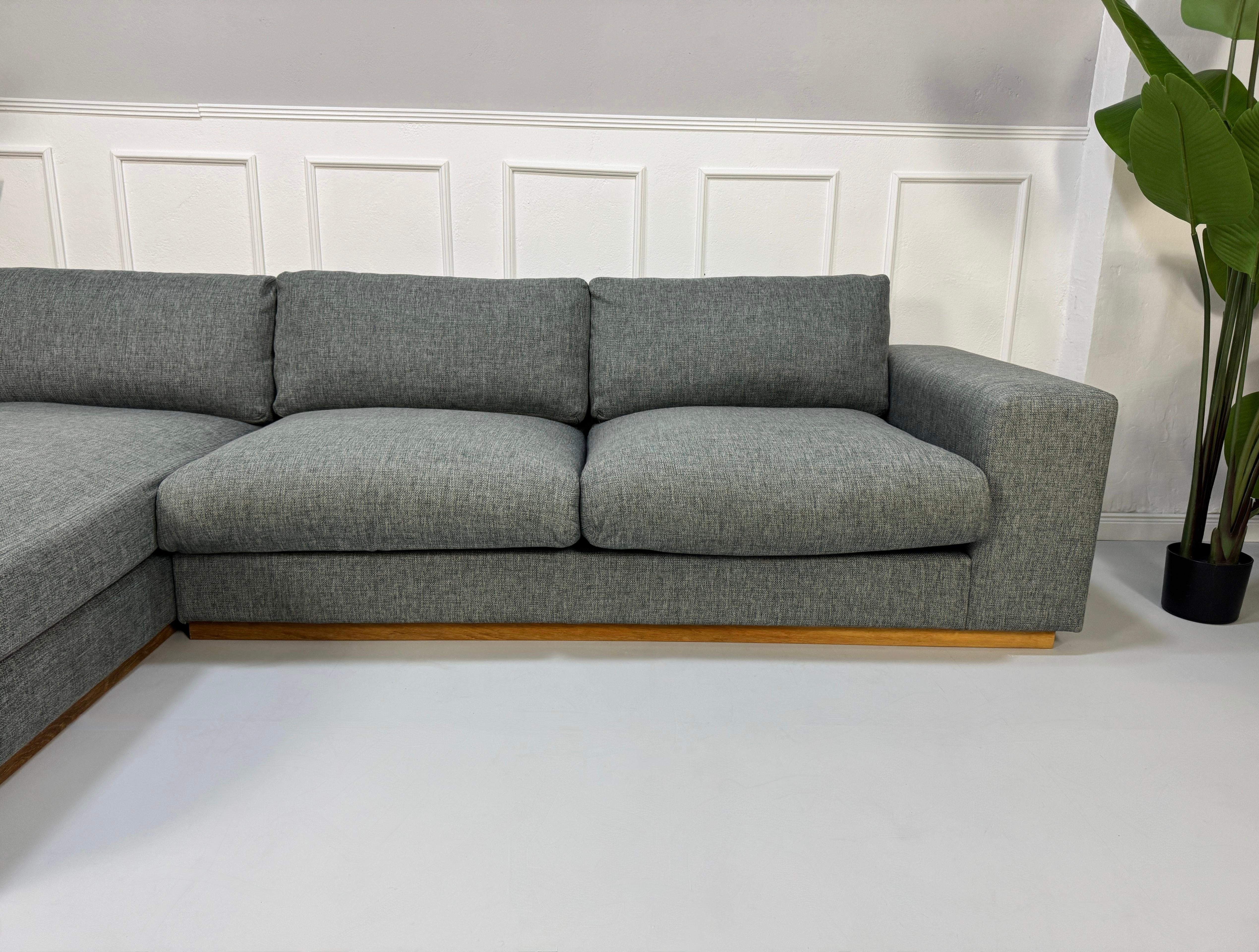 Refurbished graues Bolia Sepia Designer Stoff Sofa vor einer Wand, stilvoll und modern eingerichtet.