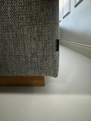 Refurbished graues Bolia Sepia Designer Stoff Sofa vor einer Wand, stilvoll und modern eingerichtet.