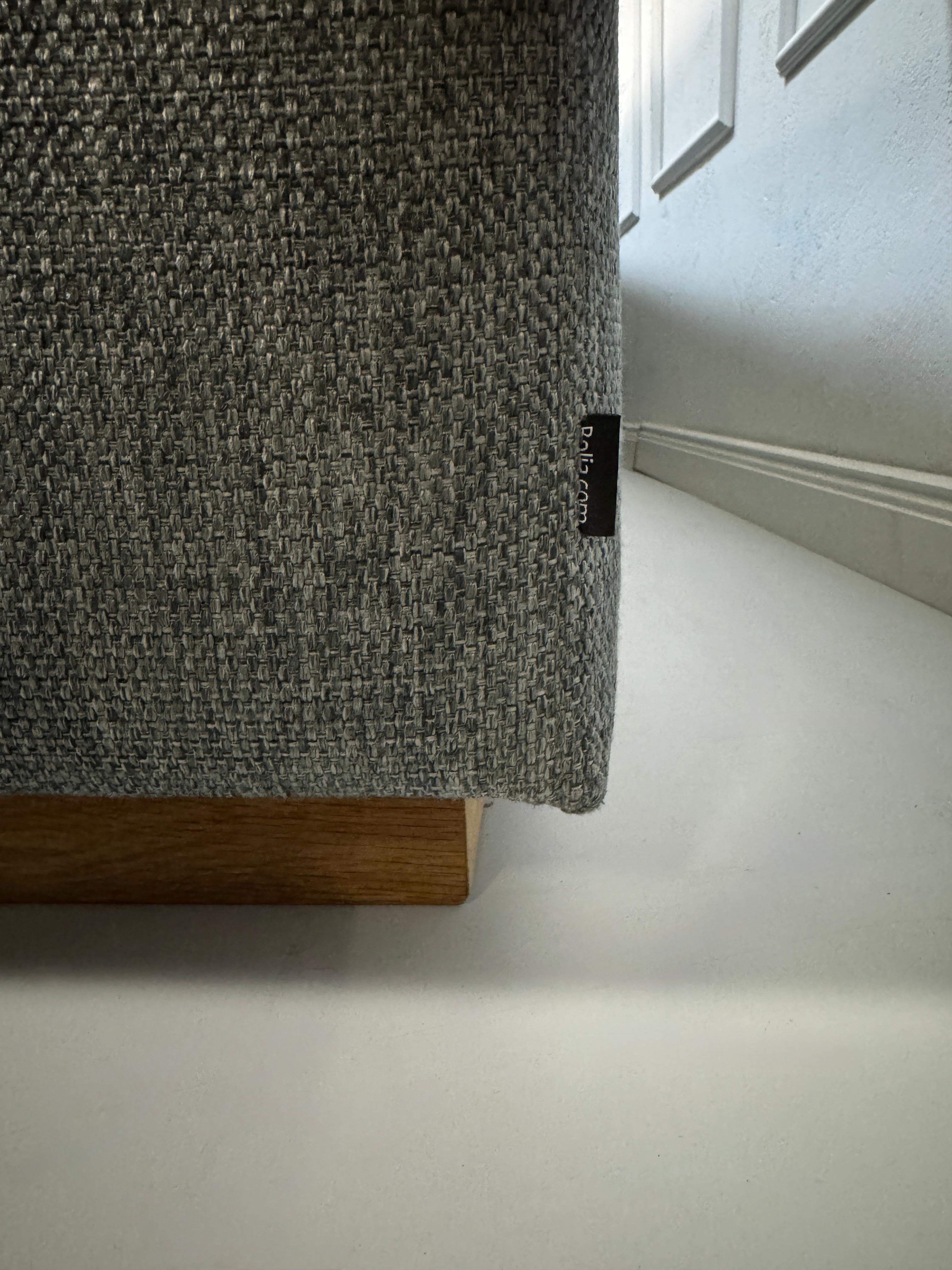 Refurbished graues Bolia Sepia Designer Stoff Sofa vor einer Wand, stilvoll und modern eingerichtet.