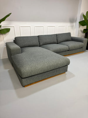 Refurbished graues Bolia Sepia Designer Stoff Sofa vor einer Wand, stilvoll und modern eingerichtet.