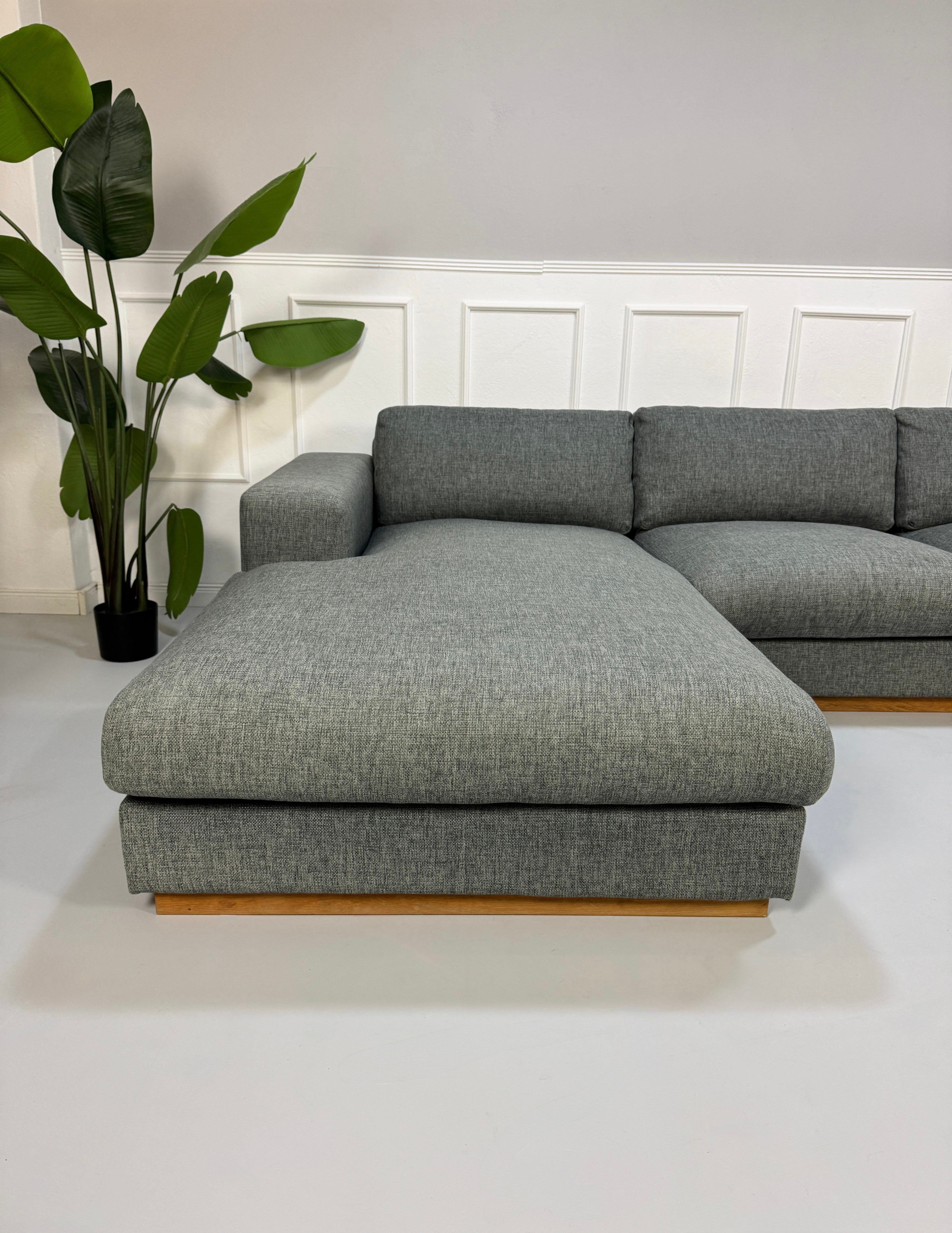 Refurbished graues Bolia Sepia Designer Stoff Sofa vor einer Wand, stilvoll und modern eingerichtet.