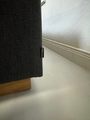 Gebrauchtes graues Bolia Sepia Designer Stoff Sofa mit Hocker vor einer Wand, stilvoll und modern eingerichtet.