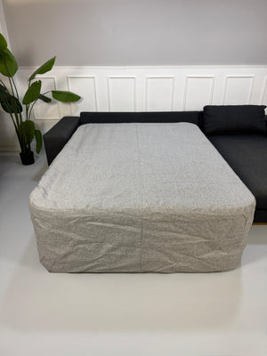 Gebrauchtes graues Bolia Sepia Designer Stoff Sofa mit Hocker vor einer Wand, stilvoll und modern eingerichtet.