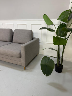 Gebrauchtes graues Bolia Designer Stoff Sofa vor einer Wand, stilvoll und modern eingerichtet.