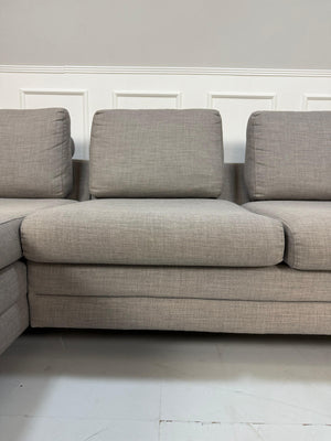 Gebrauchtes graues Bolia Designer Stoff Sofa vor einer Wand, stilvoll und modern eingerichtet.