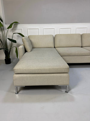 Gebrauchtes beiges Brühl Alba Designer Stoff Sofa vor einer Wand, stilvoll und modern eingerichtet.