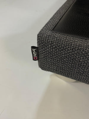 Ausstellungsstück Brühl Fourtwo Grau  Designer Stoff Sofa vor einer Wand, stilvoll und modern eingerichtet.