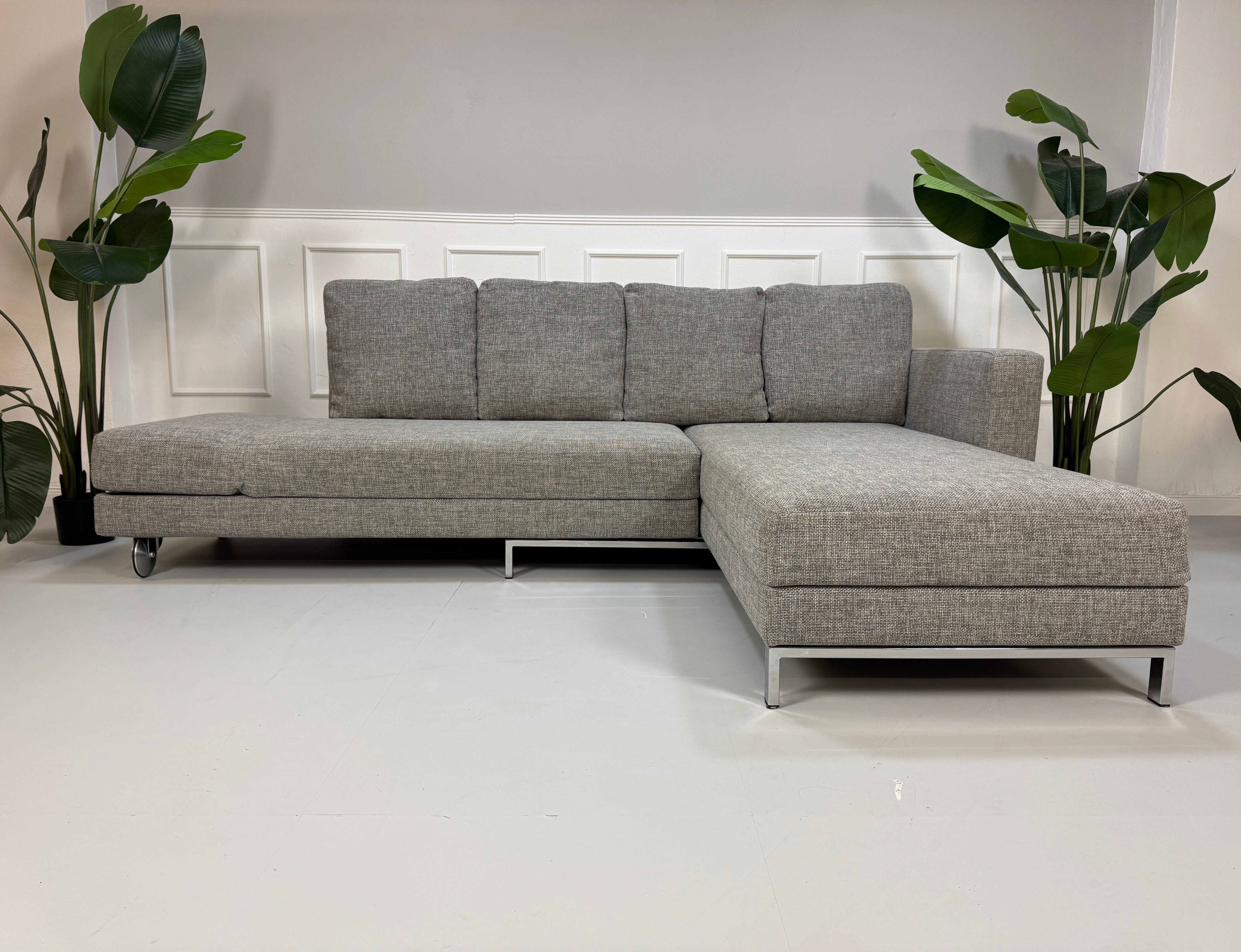 Gebrauchtes Brühl FourTwo Stoff Sofa in der Farbe Grau vor einer Wand, stilvoll und modern eingerichtet.