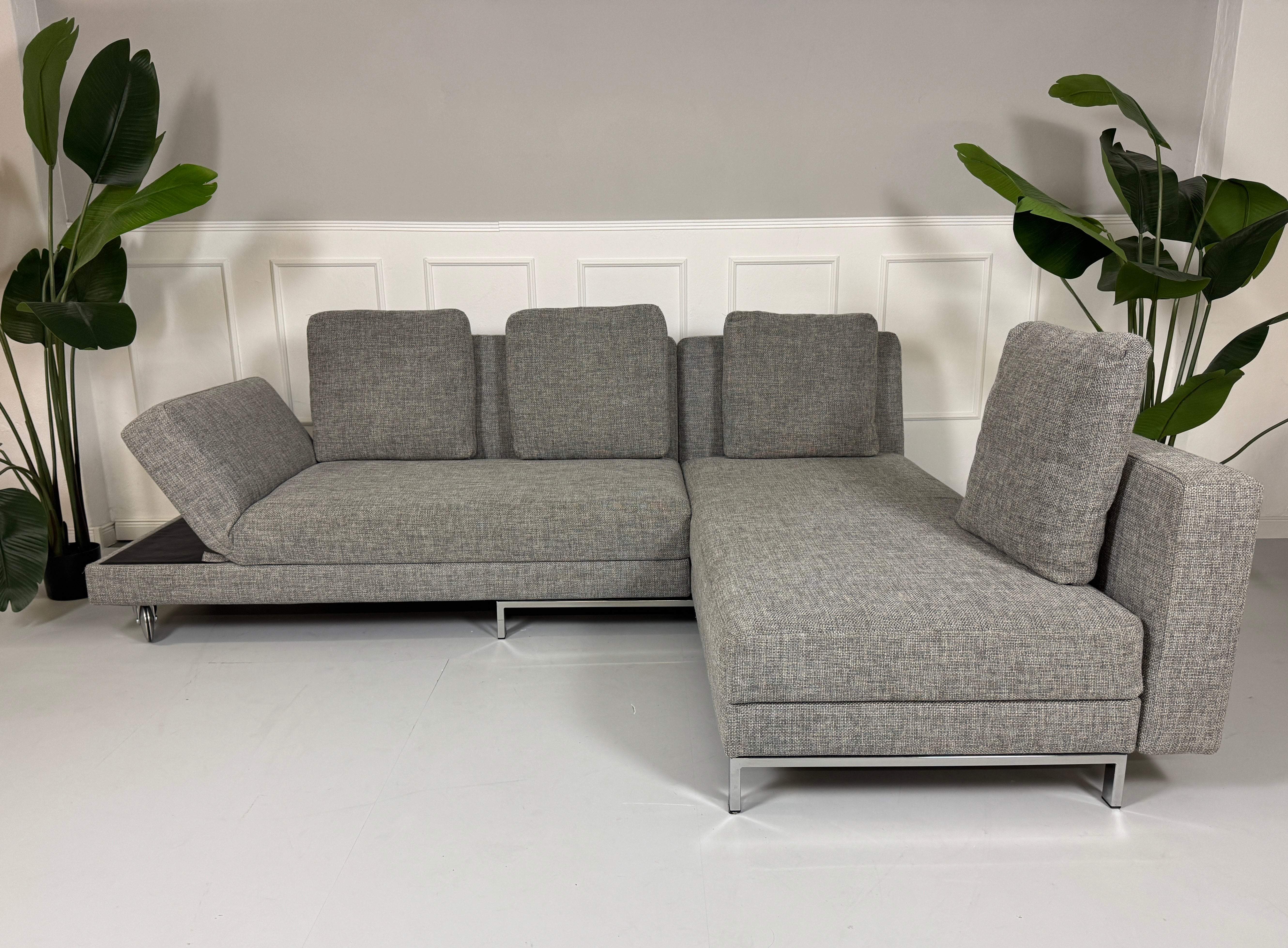 Gebrauchtes Brühl FourTwo Stoff Sofa in der Farbe Grau vor einer Wand, stilvoll und modern eingerichtet.