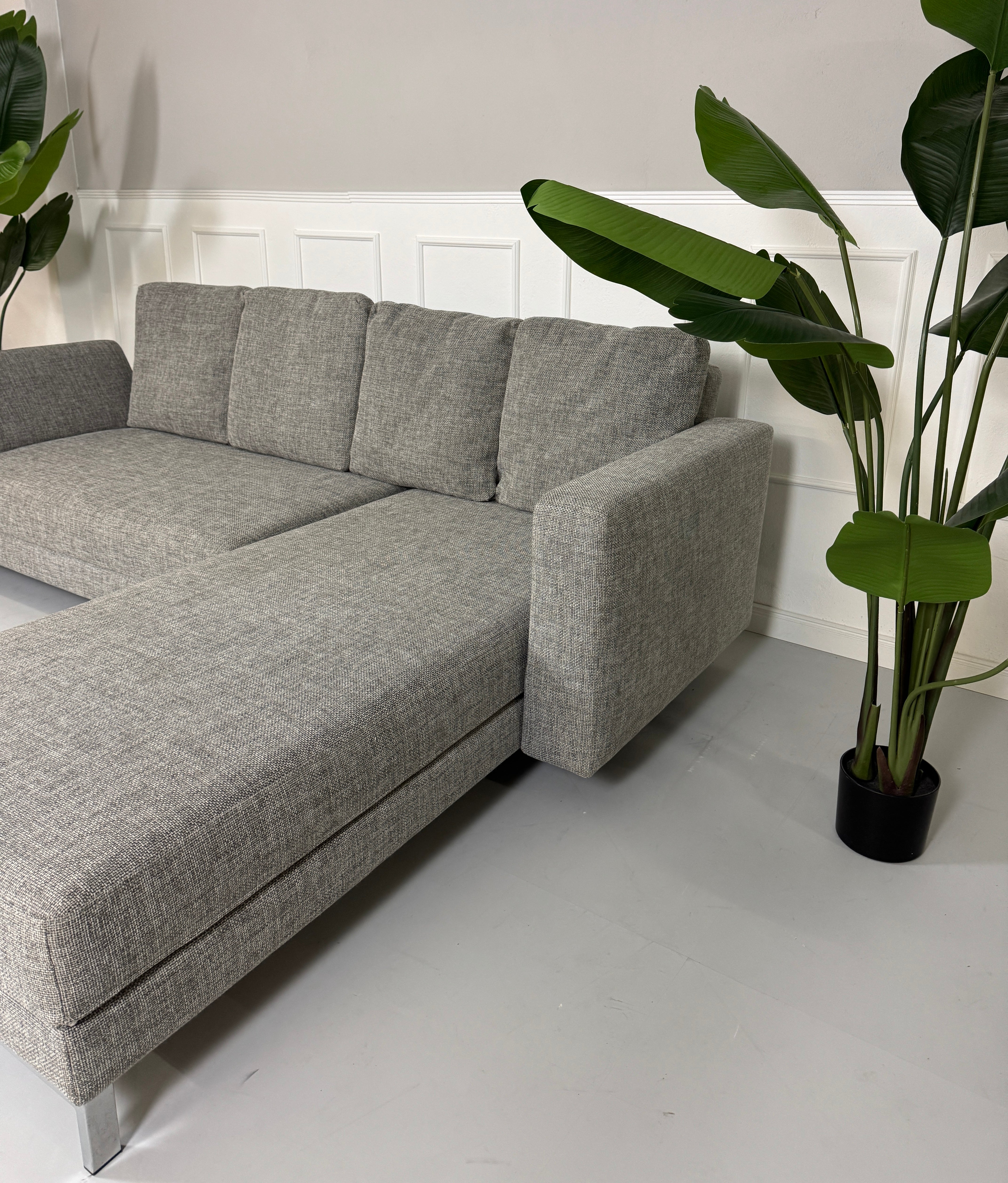 Gebrauchtes Brühl FourTwo Stoff Sofa in der Farbe Grau vor einer Wand, stilvoll und modern eingerichtet.