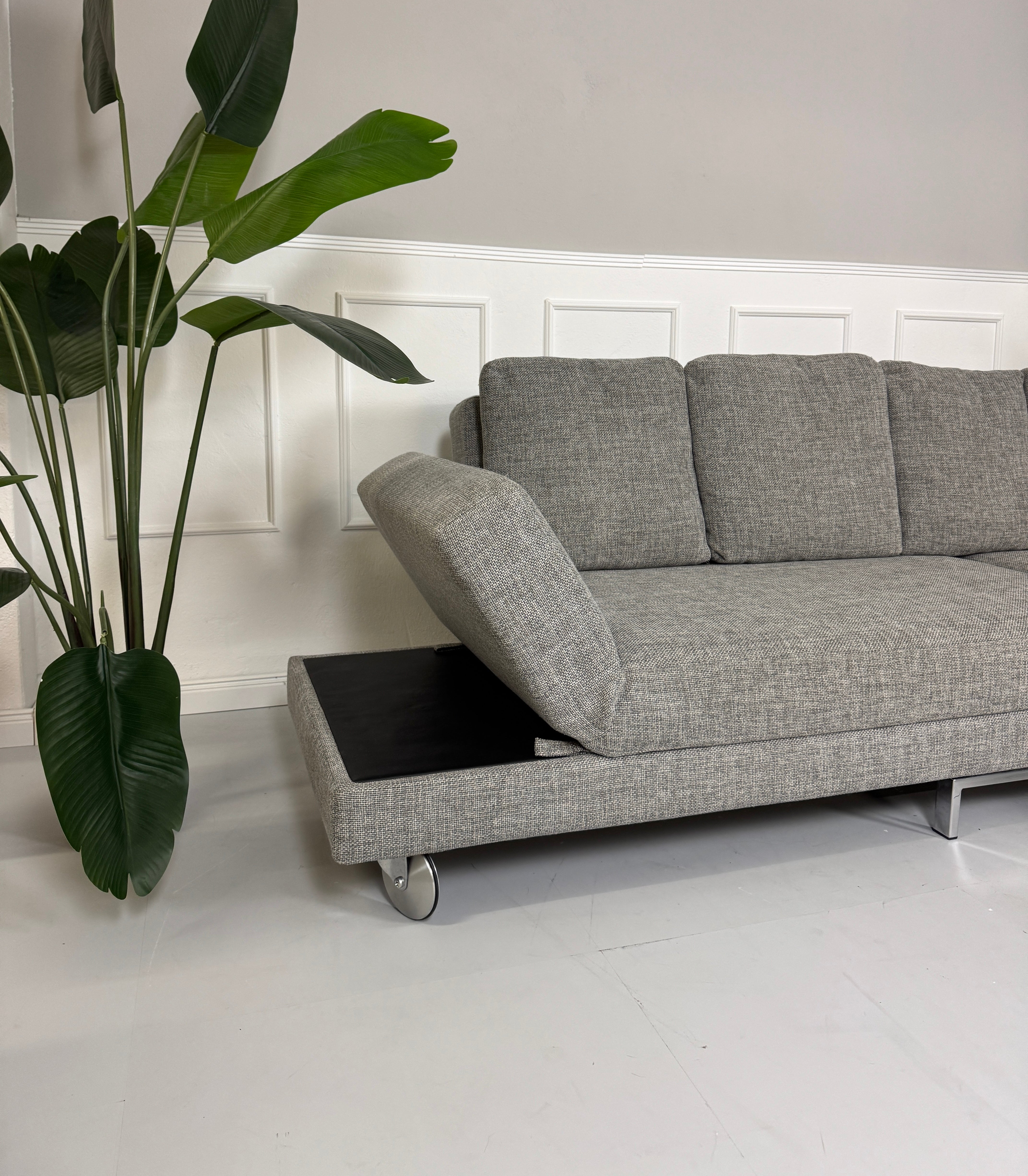 Gebrauchtes Brühl FourTwo Stoff Sofa in der Farbe Grau vor einer Wand, stilvoll und modern eingerichtet.