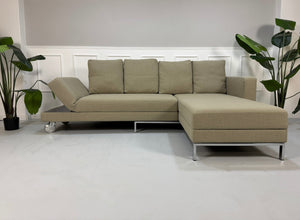 Gebrauchtes graues Brühl Fourtwo Designer Stoff Sofa vor einer Wand, stilvoll und modern eingerichtet.