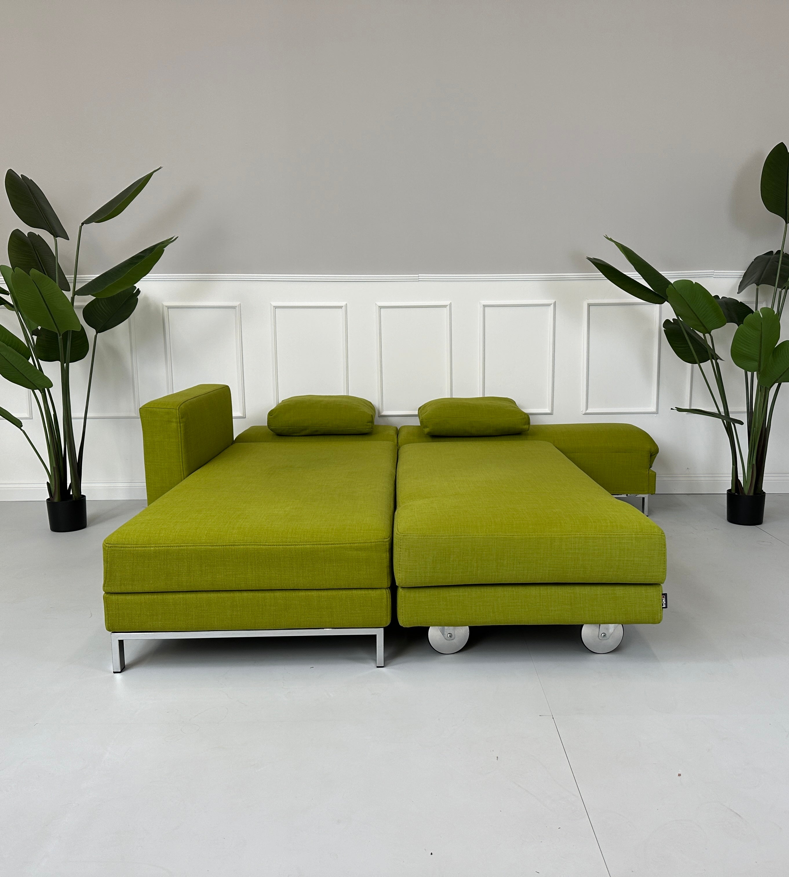 Gebrauchtes Brühl FourTwo Stoff Sofa in der Farbe Grün vor einer Wand, stilvoll und modern eingerichtet.