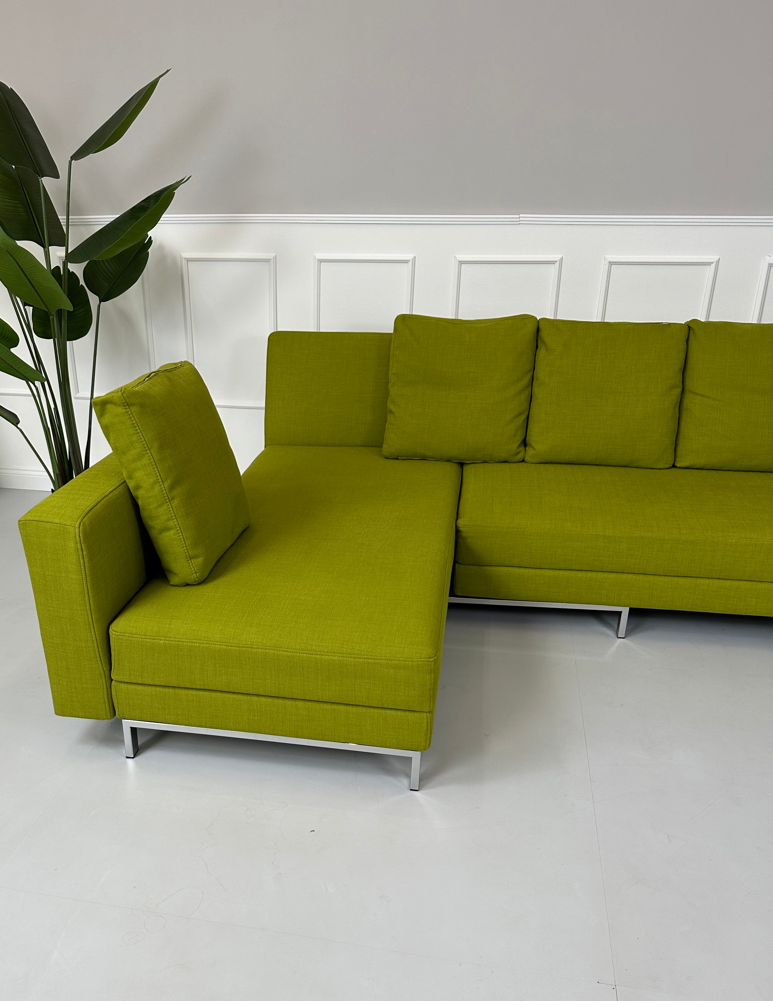 Gebrauchtes Brühl FourTwo Stoff Sofa in der Farbe Grün vor einer Wand, stilvoll und modern eingerichtet.