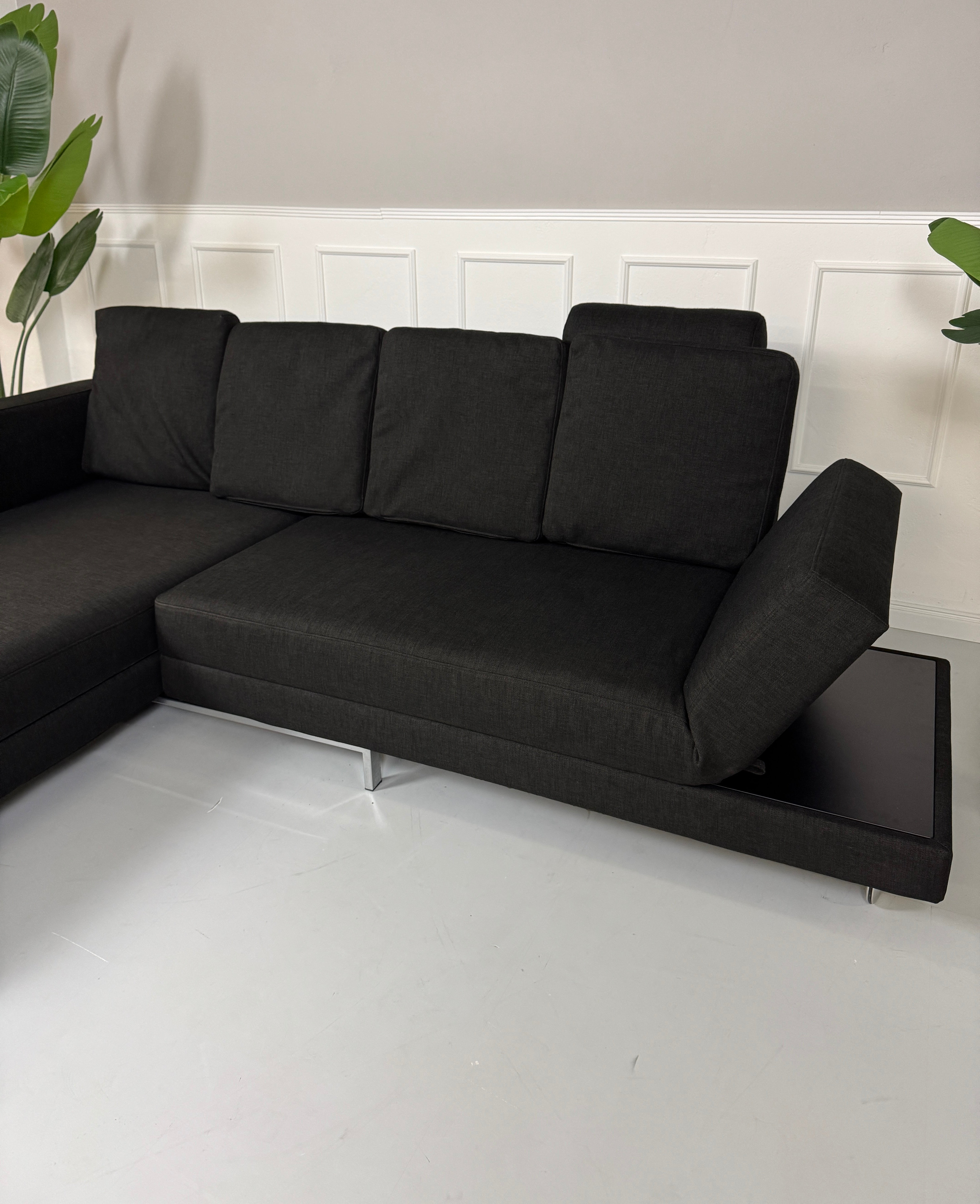 Gebrauchtes Brühl FourTwo Stoff Sofa in der Farbe Schwarz vor einer Wand, stilvoll und modern eingerichtet.