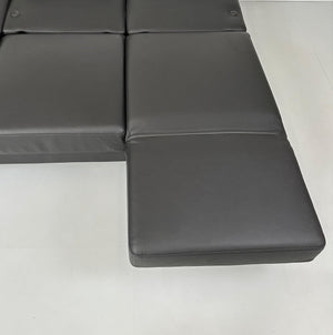 Gebrauchtes Brühl Moule Small 3-Sitzer Sofa Leder in der Farbe Schwarz vor einer Wand, stilvoll und modern eingerichtet.