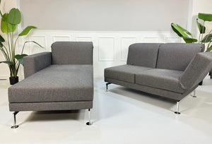 Gebrauchtes graues Brühl Moule Small Designer Stoff Sofa vor einer Wand, stilvoll und modern eingerichtet.