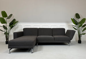 Gebrauchtes lila Brühl Moule Designer Stoff Sofa vor einer Wand, stilvoll und modern eingerichtet.