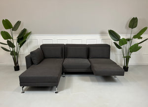 Gebrauchtes lila Brühl Moule Designer Stoff Sofa vor einer Wand, stilvoll und modern eingerichtet.