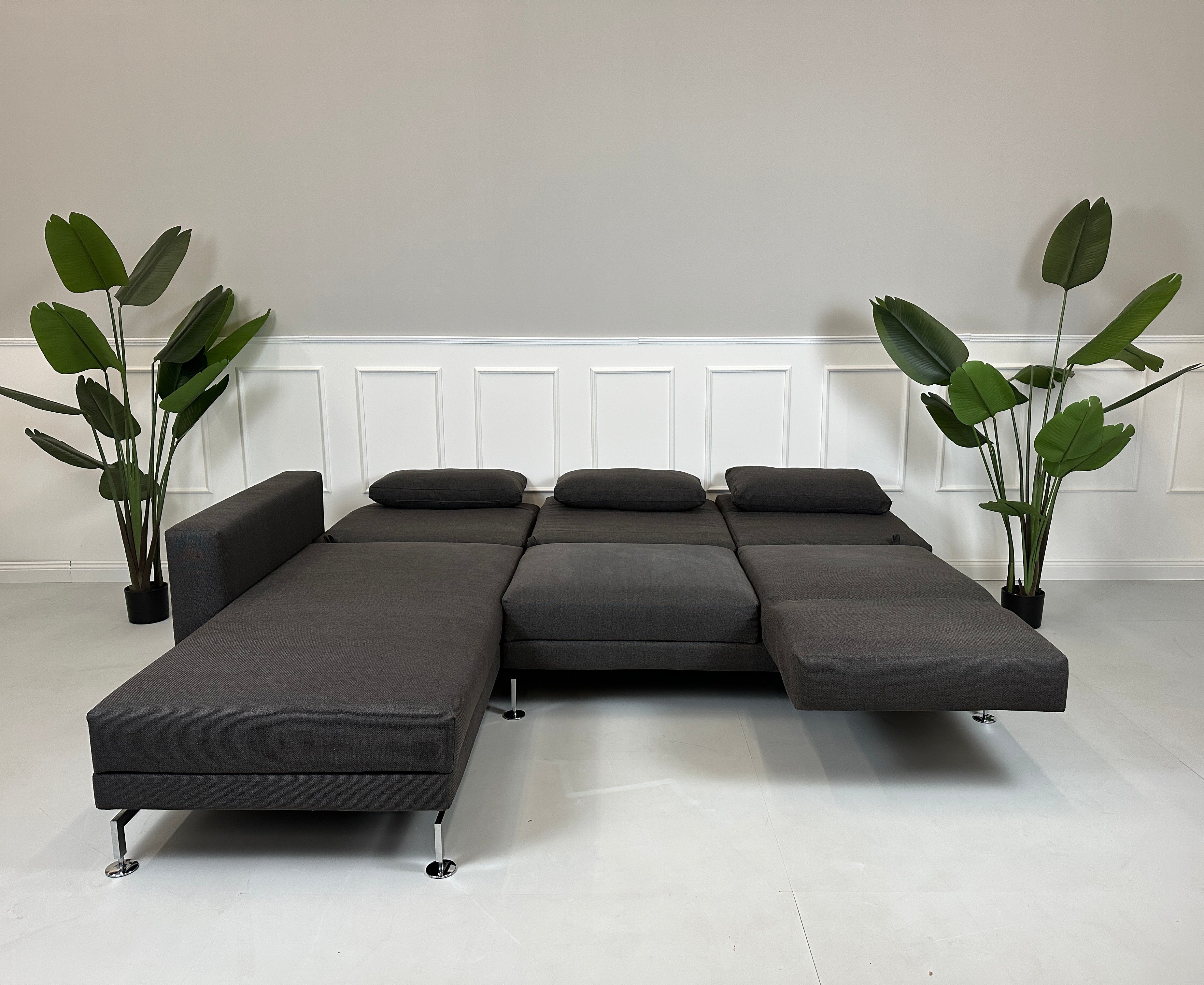 Gebrauchtes lila Brühl Moule Designer Stoff Sofa vor einer Wand, stilvoll und modern eingerichtet.