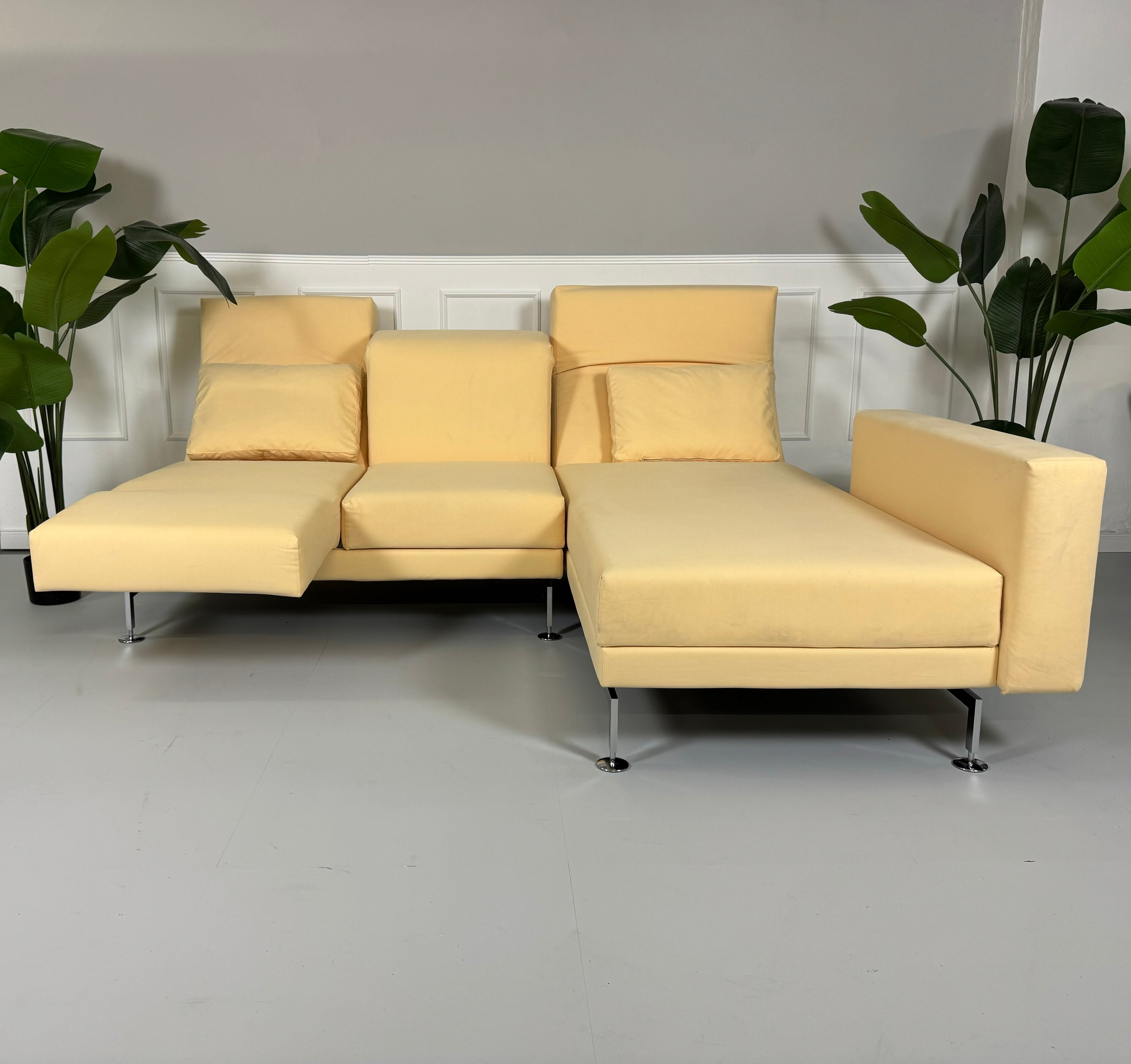 Gebrauchtes Brühl Moule Small Ecksofa Stoff in der Farbe Beige vor einer Wand, stilvoll und modern eingerichtet.