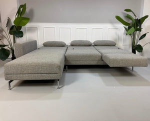 Gebrauchtes Brühl Moule Designer Stoff Sofa vor einer Wand, stilvoll und modern eingerichtet.
