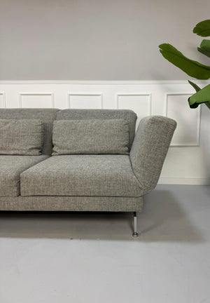 Gebrauchtes Brühl Moule Designer Stoff Sofa vor einer Wand, stilvoll und modern eingerichtet.
