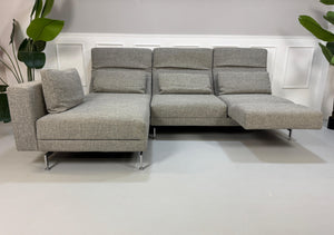 Gebrauchtes Brühl Moule Designer Stoff Sofa vor einer Wand, stilvoll und modern eingerichtet.
