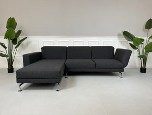 Gebrauchtes graues Brühl Moule Designer Stoff Sofa mit Hocker vor einer Wand, stilvoll und modern eingerichtet.