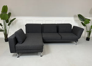 Gebrauchtes graues Brühl Moule Designer Stoff Sofa mit Hocker vor einer Wand, stilvoll und modern eingerichtet.