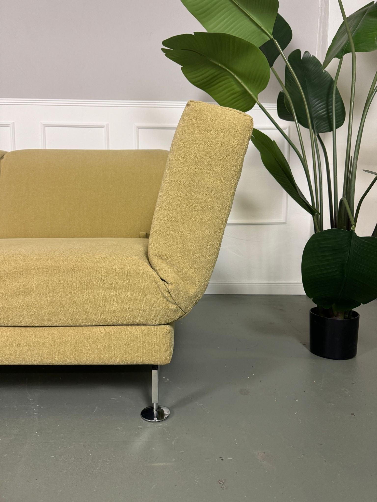 Gebrauchtes Brühl Moule Ecksofa Stoff in der Farbe Grün Beige vor einer Wand, stilvoll und modern eingerichtet.