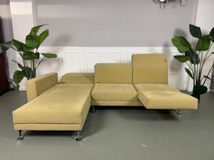 Gebrauchtes Brühl Moule Ecksofa Stoff in der Farbe Grün Beige vor einer Wand, stilvoll und modern eingerichtet.