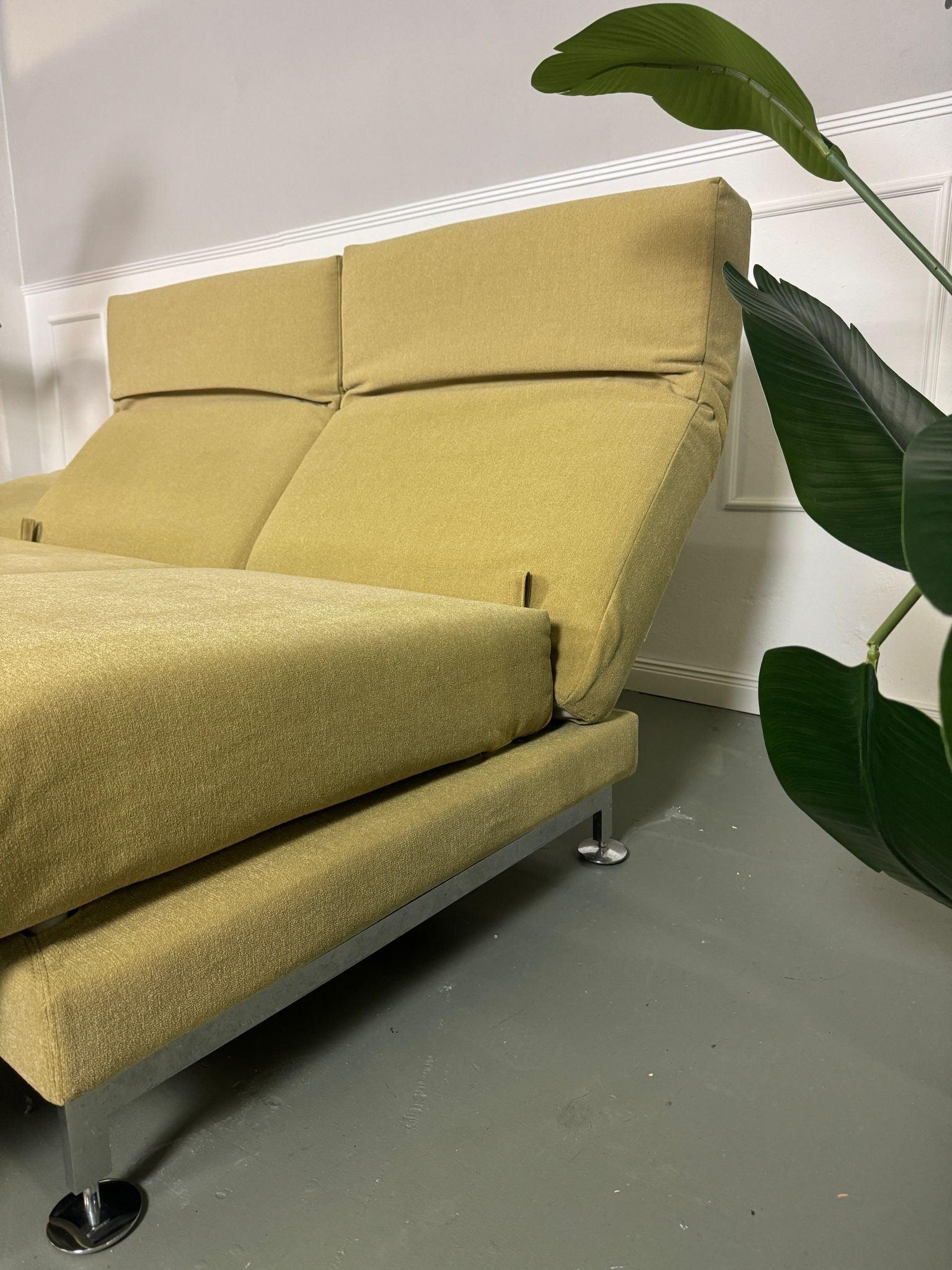 Gebrauchtes Brühl Moule Ecksofa Stoff in der Farbe Grün Beige vor einer Wand, stilvoll und modern eingerichtet.