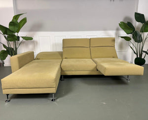 Gebrauchtes Brühl Moule Ecksofa Stoff in der Farbe Grün Beige vor einer Wand, stilvoll und modern eingerichtet.