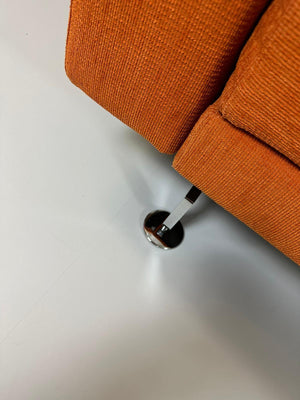 Gebrauchtes Brühl Moule Ecksofa Stoff in der Farbe Orange vor einer Wand, stilvoll und modern eingerichtet.