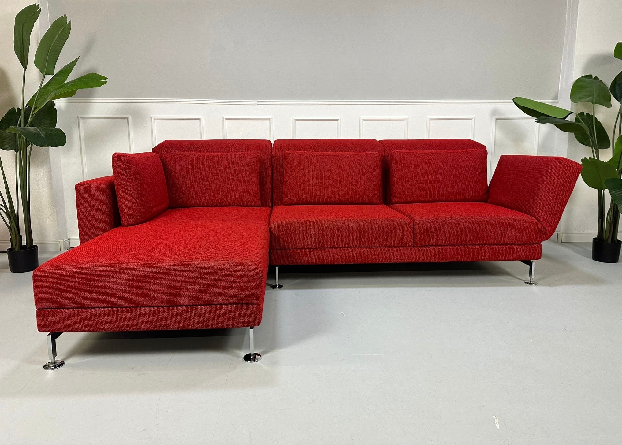 Gebrauchtes Brühl Moule Stoff Ecksofa in der Farbe Rot vor einer Wand, stilvoll und modern eingerichtet.