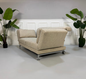 Gebrauchtes beiges Brühl Moule Designer Stoff Sofa vor einer Wand, stilvoll und modern eingerichtet.
