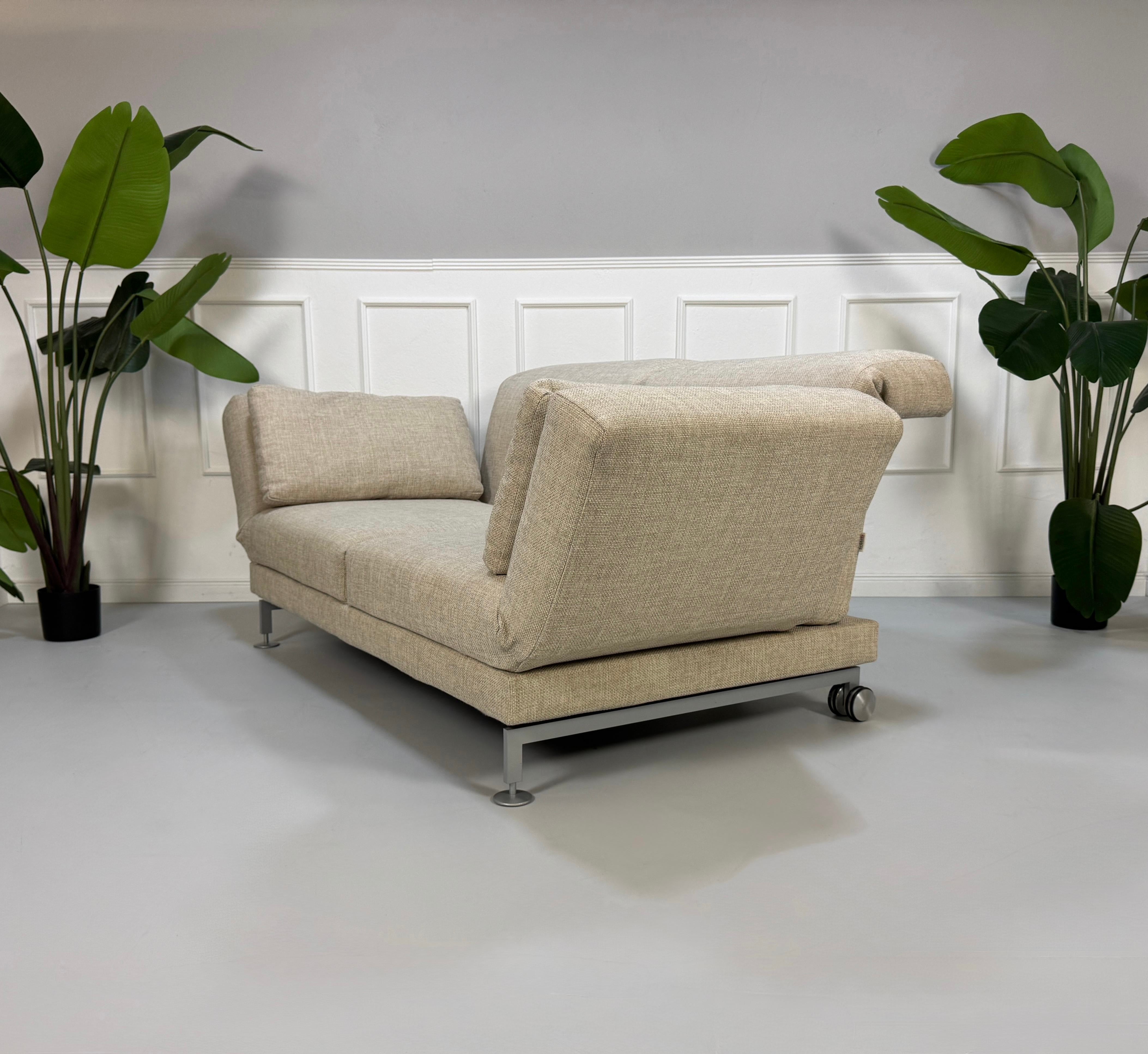 Gebrauchtes beiges Brühl Moule Designer Stoff Sofa vor einer Wand, stilvoll und modern eingerichtet.