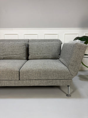 Refurbished graues Brühl Moule Designer Stoff Sofa vor einer Wand, stilvoll und modern eingerichtet.