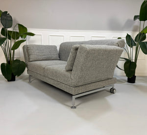 Refurbished graues Brühl Moule Designer Stoff Sofa vor einer Wand, stilvoll und modern eingerichtet.